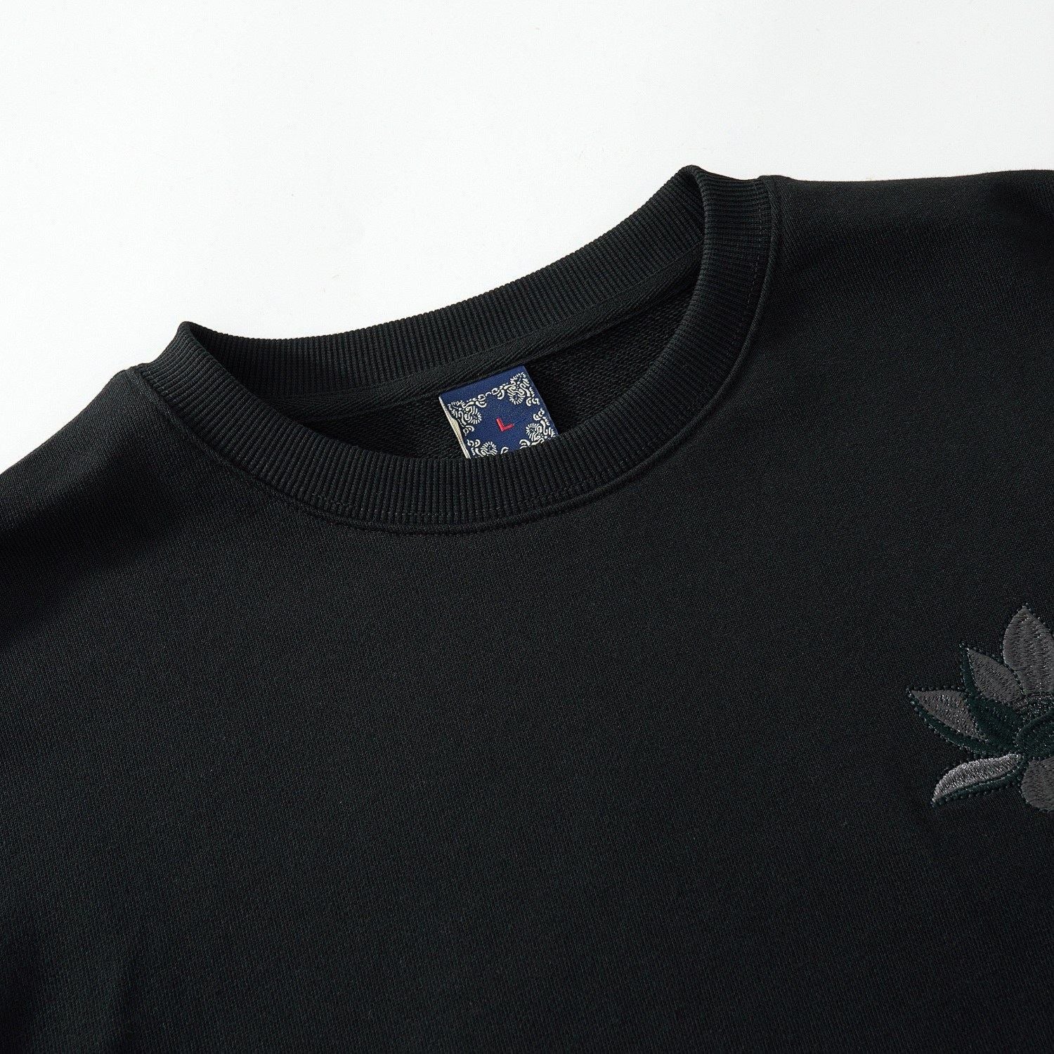 Ribbed crewneck detail of the black sweatshirt highlighting tidy construction