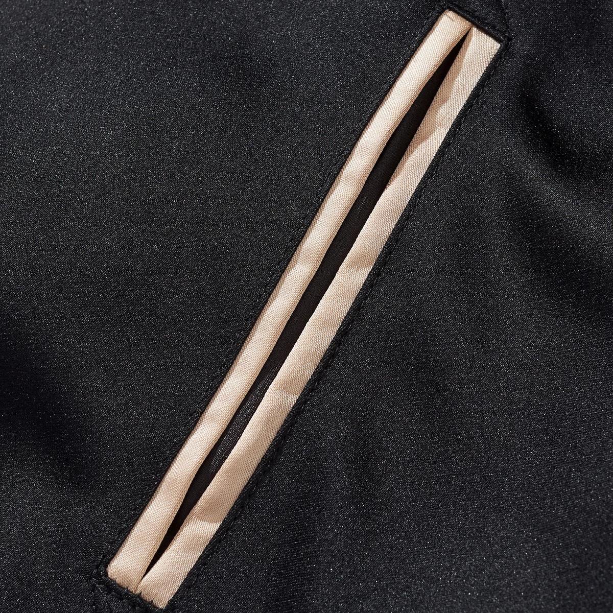 Neat welt pocket detail with beige trim on the black body