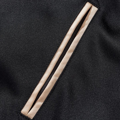 Neat welt pocket detail with beige trim on the black body