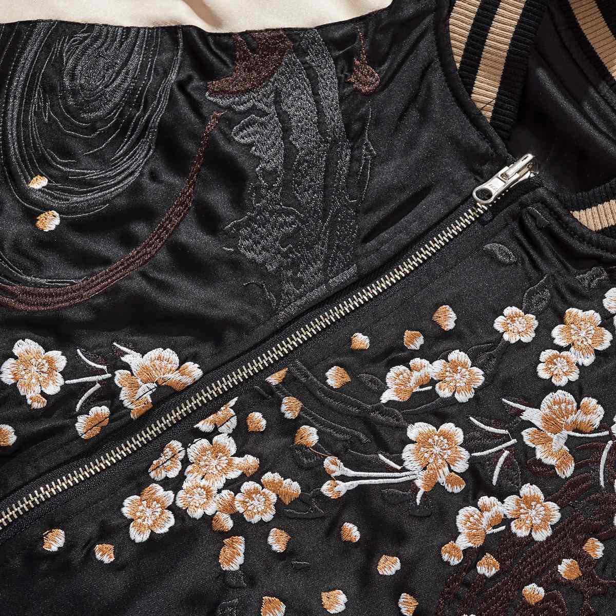 Beige color sukajan jacket chest detail featuring sakura motifs beside the front zipper.