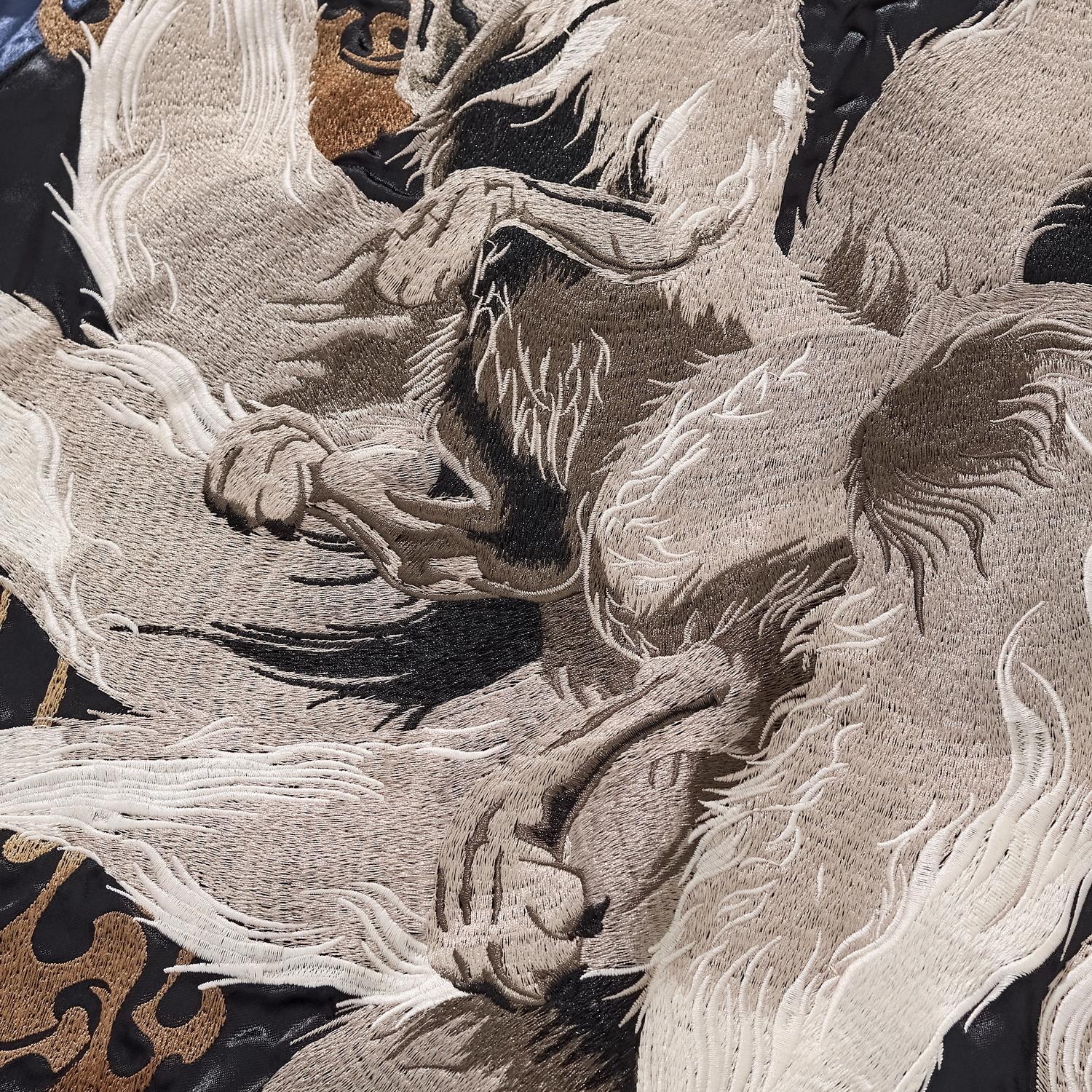 Detailed embroidery shot showing the texture of the nine tails and the fox's claws.