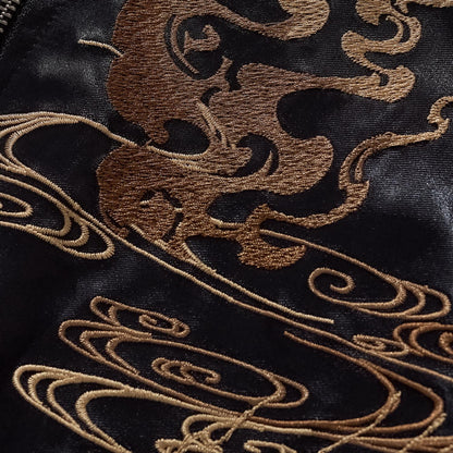 Close-up texture shot of the metallic gold thread used for the cloud and smoke embroidery.