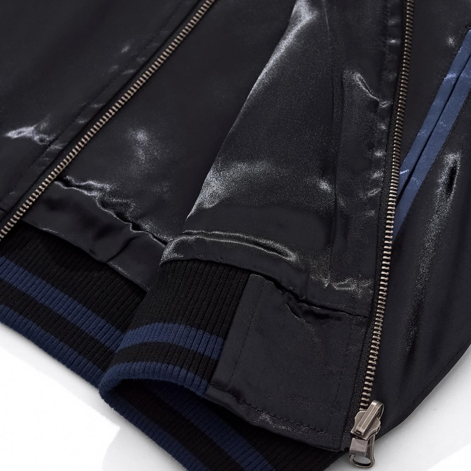 Close-up of the ribbed hem and zipper base showing the blue side panel construction.