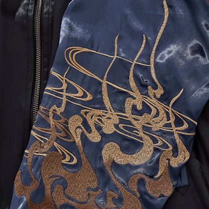 Detail of the golden cloud and smoke embroidery on the midnight blue satin sleeve.