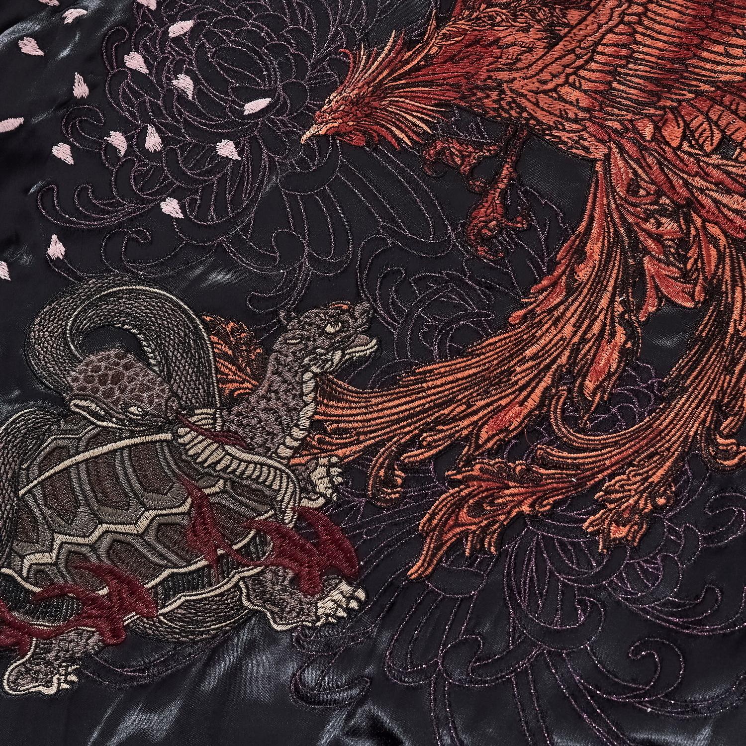 Close-up showing the interaction between the heavy beast embroidery and the delicate background stitching.