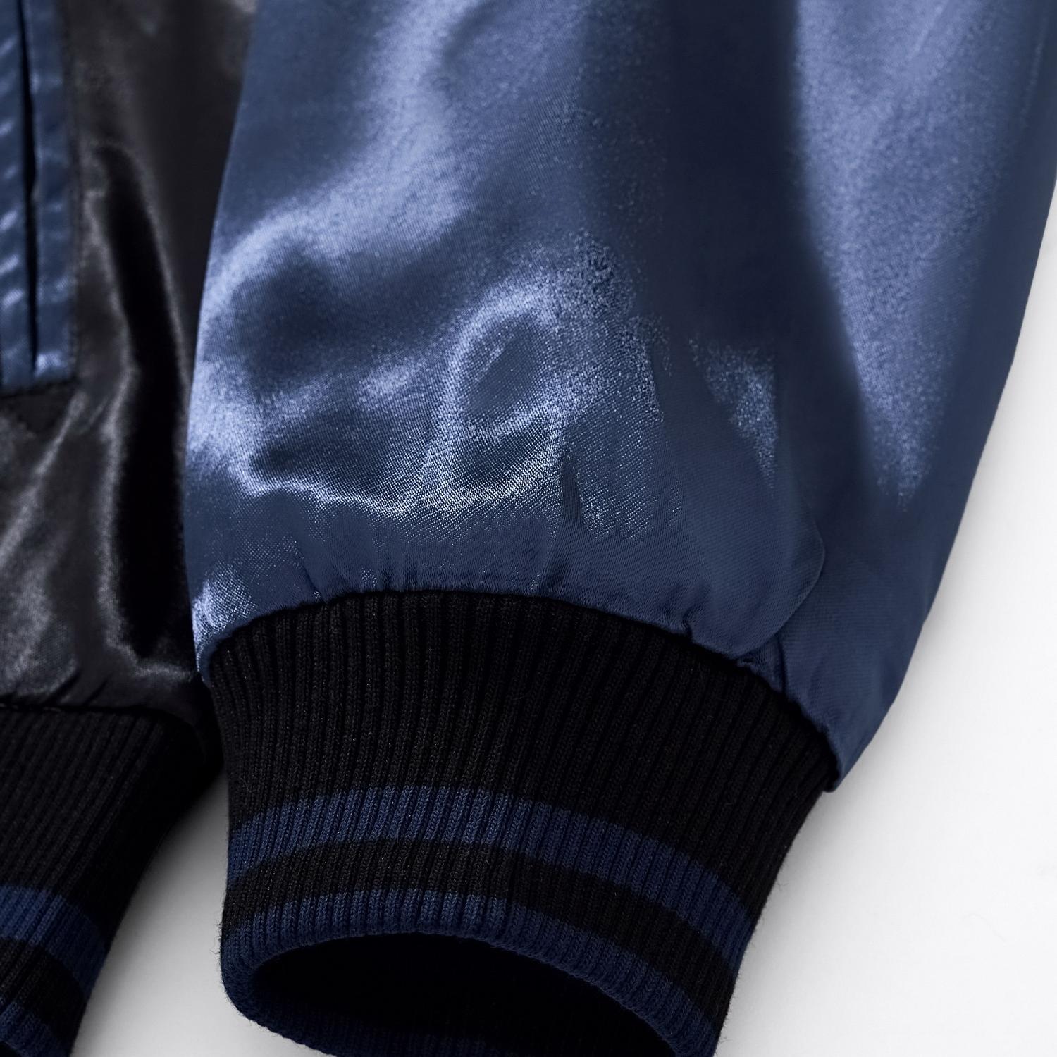 Detail shot of the elastic ribbed cuff and the smooth texture of the blue rayon satin sleeve.