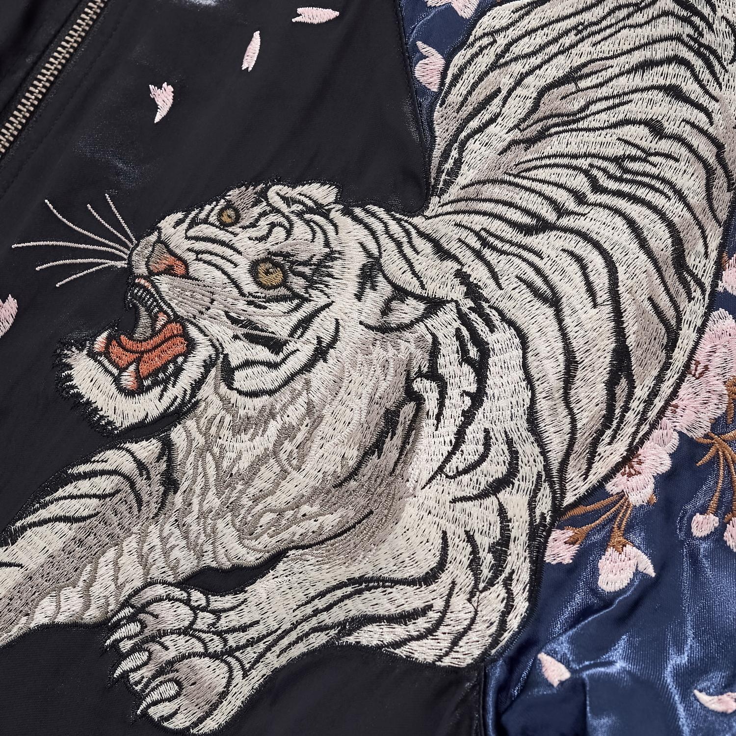 Extreme close-up of the White Tiger chest embroidery showing fur texture and facial expression.
