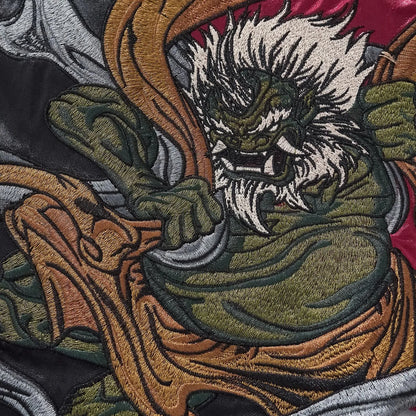 Macro shot showing the high-density thread texture of the Japanese mythology embroidery.