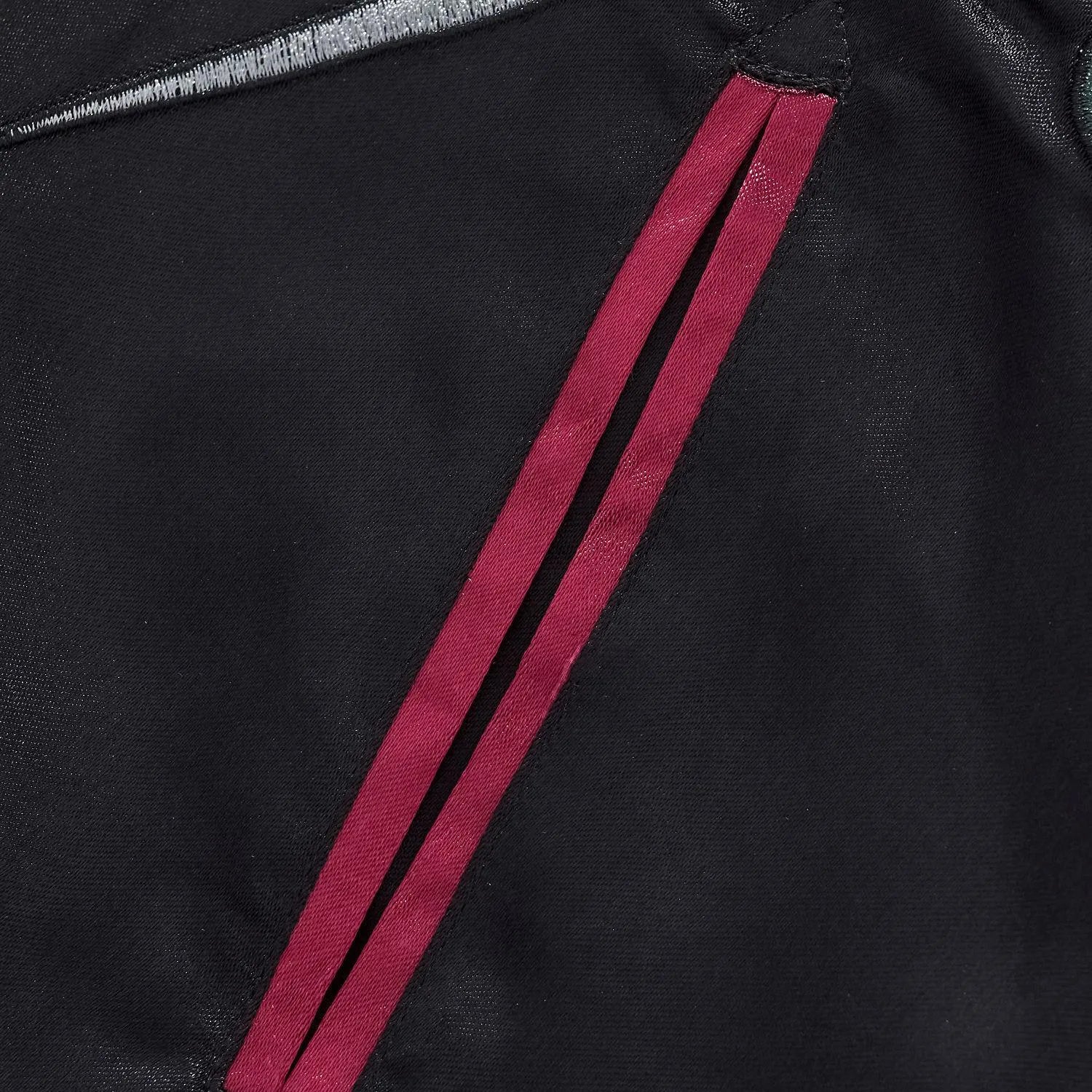 Detail of the reinforced side welt pocket with burgundy trim.