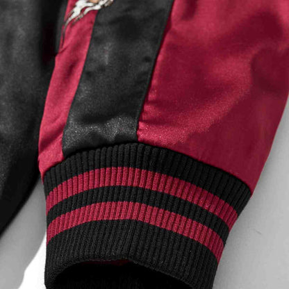Close-up of ribbed cuff on burgundy color reversible dragon & peony sukajan jacket; black and burgundy striped knit.
