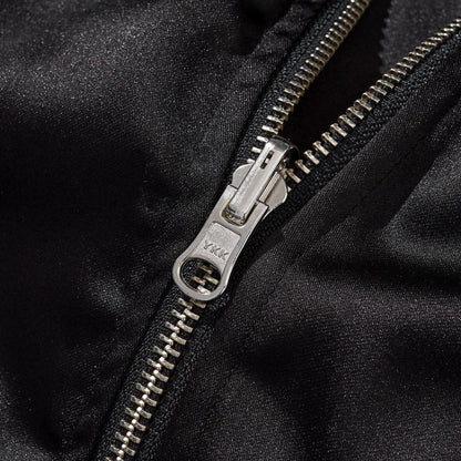 Close-up of the metal zipper with smooth satin fabric