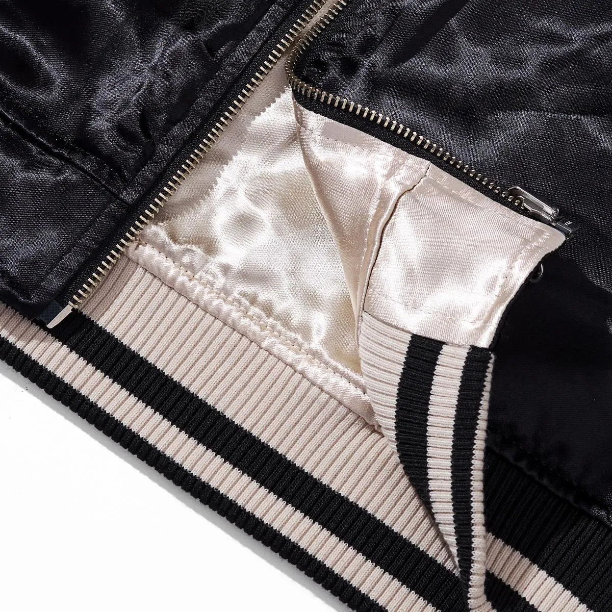 Close-up of the metal zipper base and striped ribbed hem showing the high-quality reversible construction.