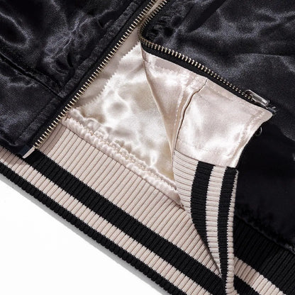 Close-up of the metal zipper base and striped ribbed hem showing the high-quality reversible construction.