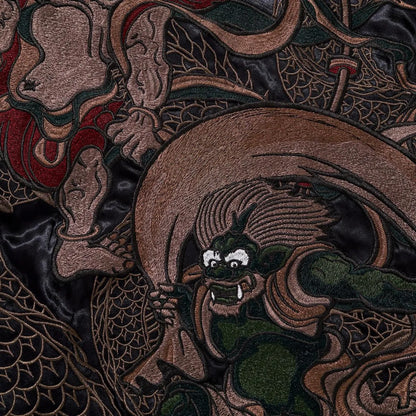 Extreme close-up of the Thunder God (Raijin) embroidery showing facial expression and craftsmanship.