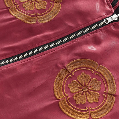 Detail of the dual floral crests embroidered on the chest with zipper hardware.
