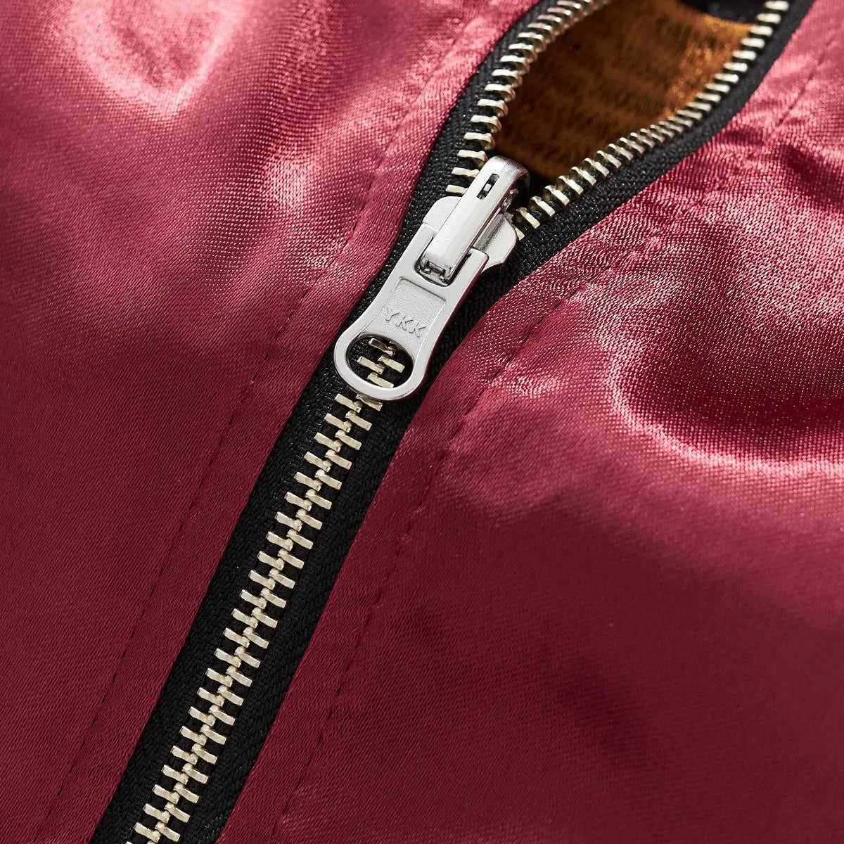 Macro photography of the durable YKK metal zipper hardware ensuring smooth reversible use.