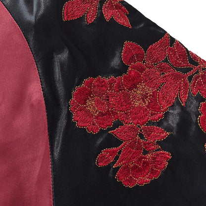 Detailed shot of the red peony flower embroidery on the black satin shoulder area.