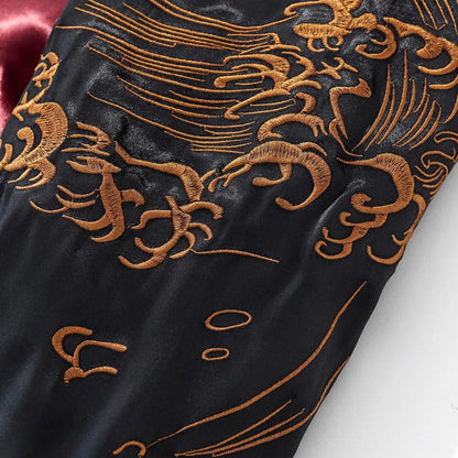 Close-up of intricate golden wave embroidery on the satin sleeve.