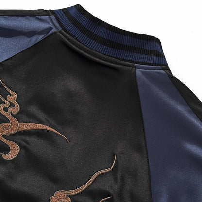 Back collar detail showing bronze cloud-crescent embroidery on black satin with navy raglan.