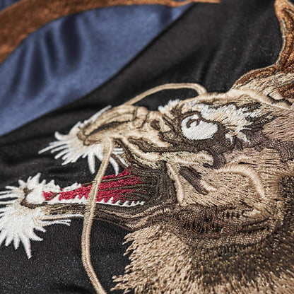 Macro detail of kirin head embroidery with white whiskers and red mouth on the navy side.