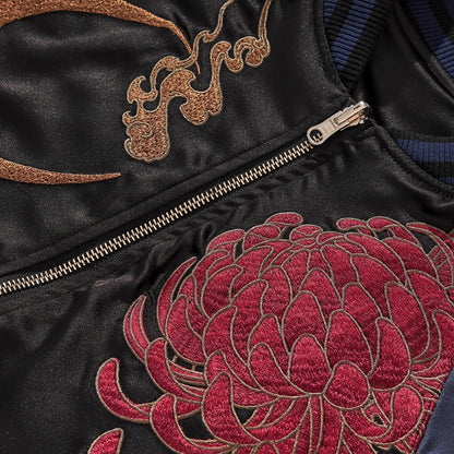 Zipper area close-up featuring bronze crescent and bold red chrysanthemum stitching, navy.
