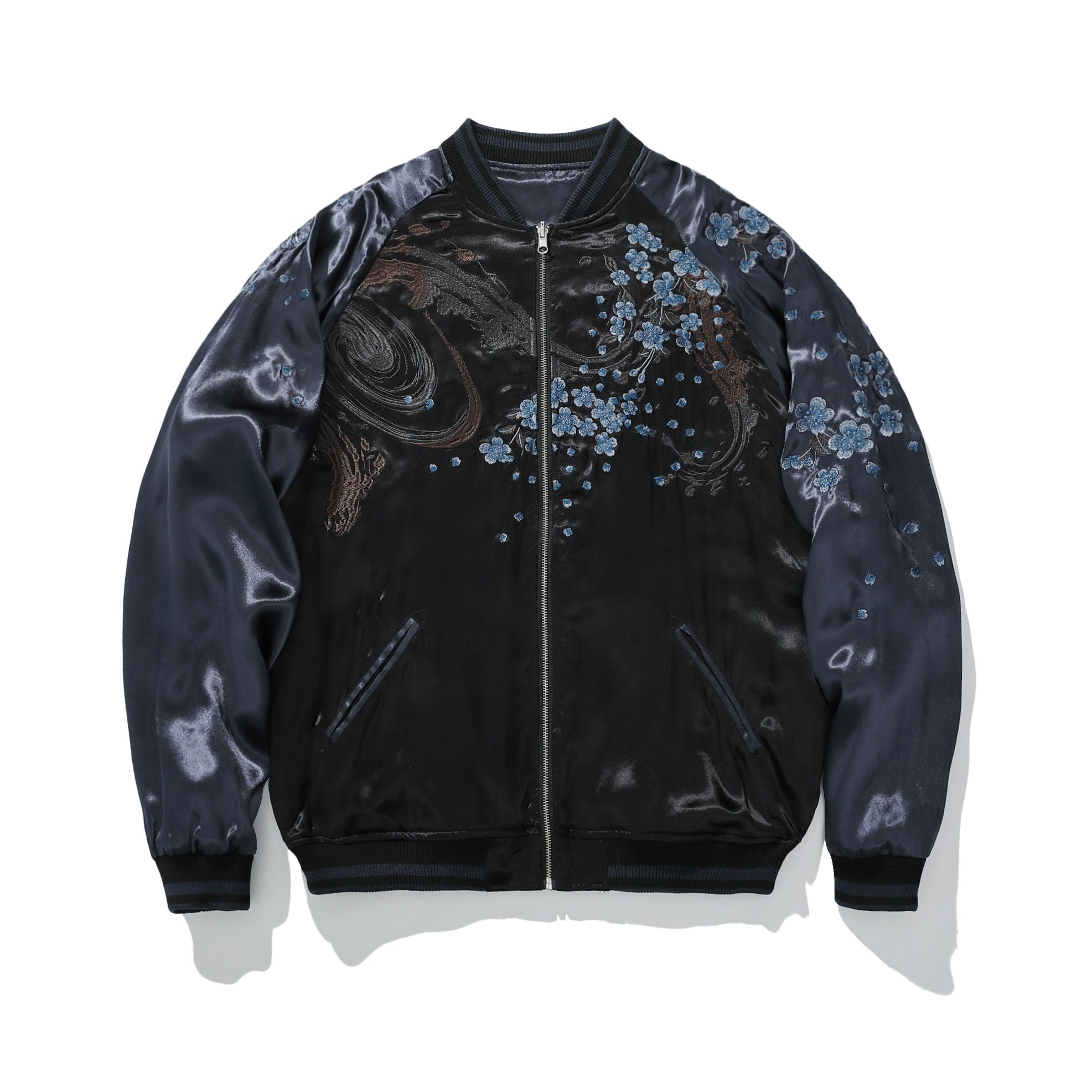 Front view—cloud swirls and branches scattered with blue blossoms; zip-up, raglan sleeves.