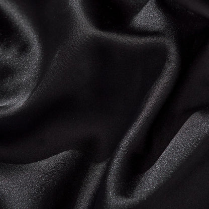 Smooth black satin fabric close-up showing soft drape and sheen