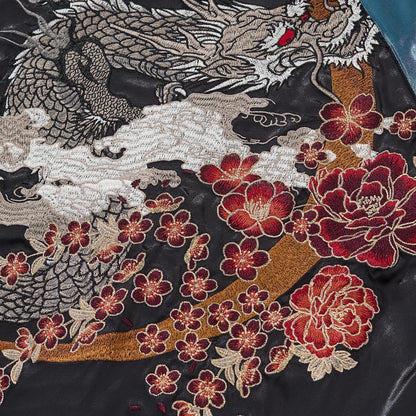 Detailed embroidery shot of the Silver Dragon's head and red eyes against the blue satin back.