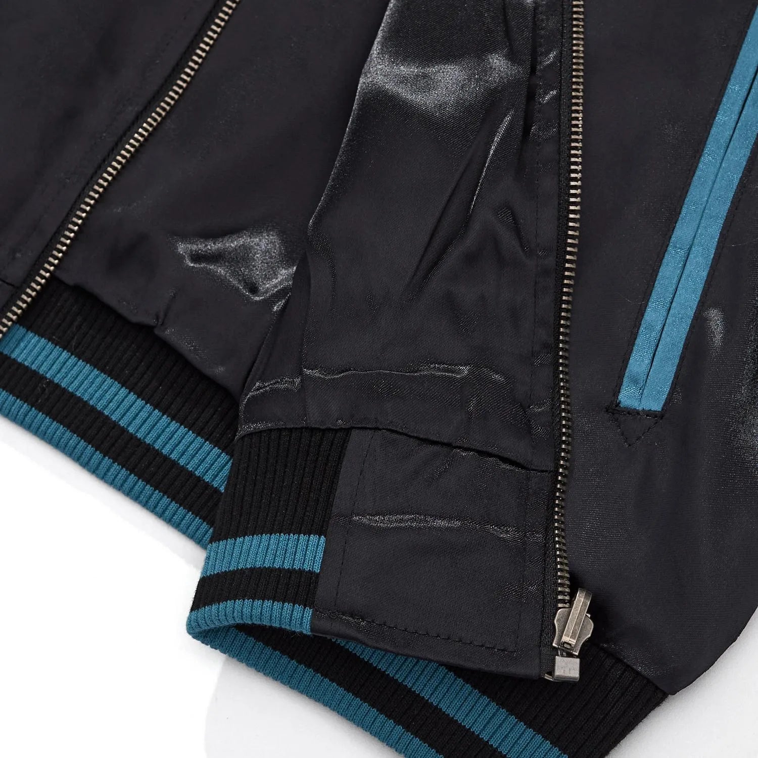 Detail of the blue striped ribbed hem and metal zipper base on the single-sided jacket.