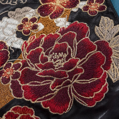 Vibrant red peony and cherry blossom embroidery contrasting against the blue satin fabric.
