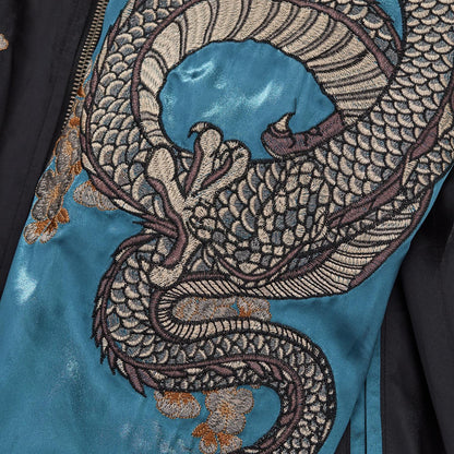 Intricate embroidery detail of the silver dragon body coiling down the blue satin sleeve.