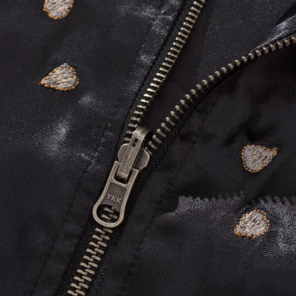 Macro shot of the antique silver YKK zipper pull surrounded by embroidered sakura petals.