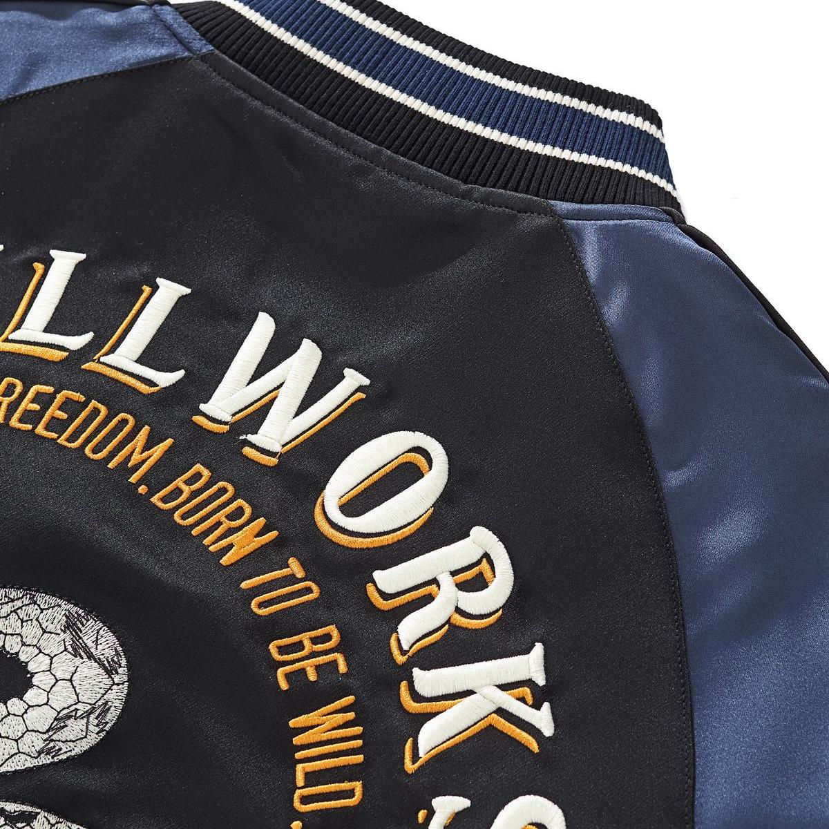 Textured snake-scale embroidery and vintage script on the back