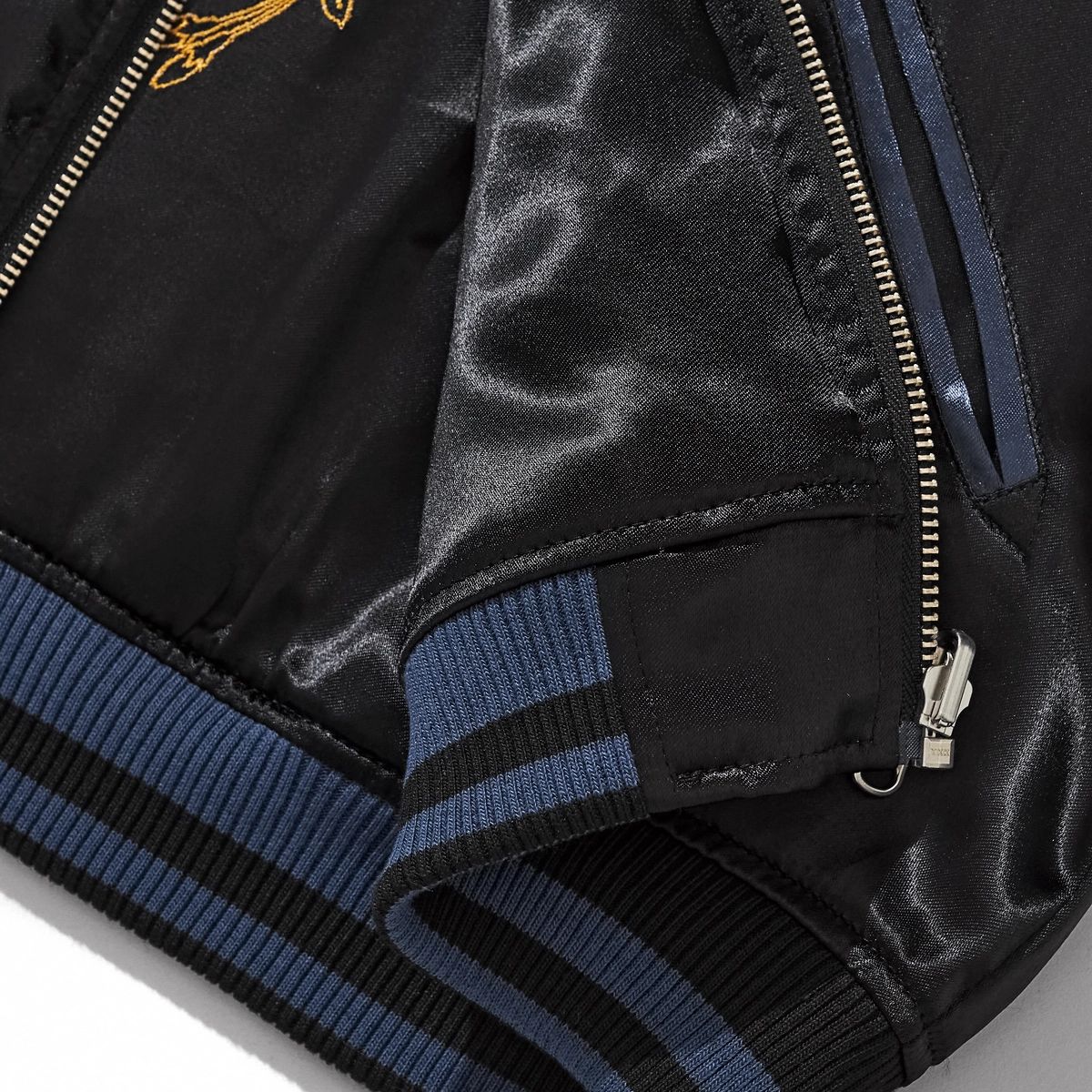 Detail of ribbed hem, zipper and pocket finish on navy side of Storm Dragons & Peony reversible sukajan.