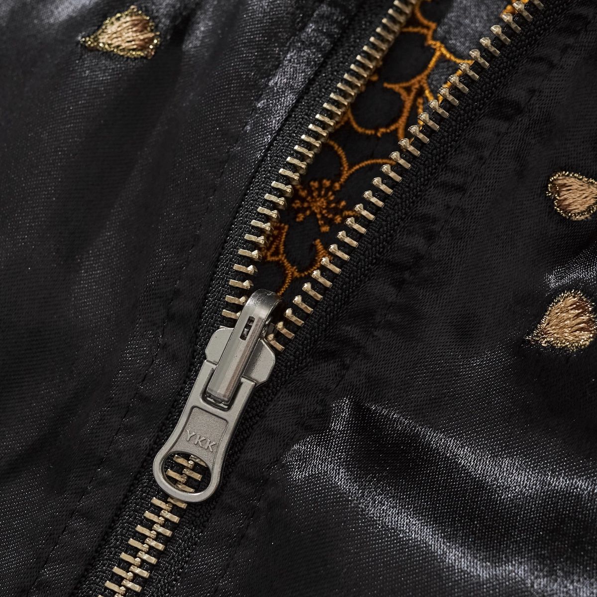 Macro detail of durable YKK zipper and patterned inner lining on Storm Dragons & Peony reversible sukajan.