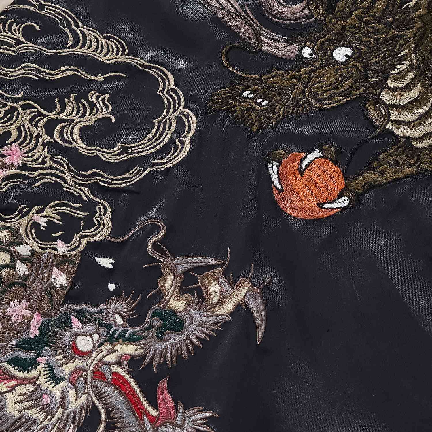 Close-up of twin dragons chasing a flaming pearl with clouds and sakura embroidery on Twin Dragons & Sakura Japanese sukajan jacket.