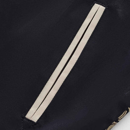 Close-up of slanted welt pocket with beige piping on navy body of Twin Dragons & Sakura sukajan jacket.