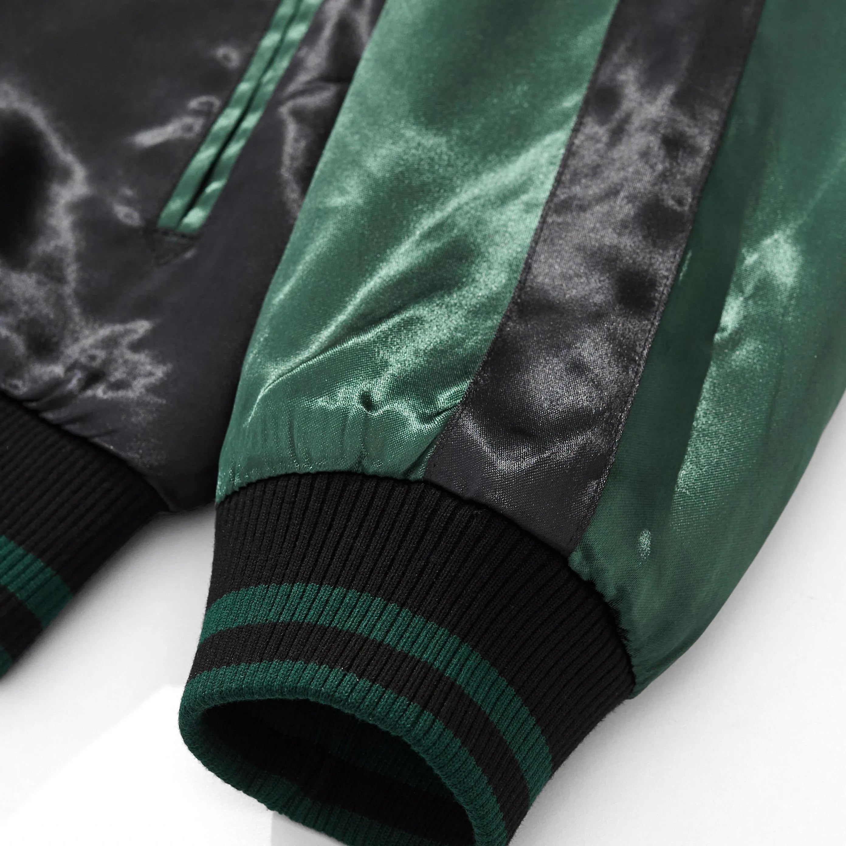 Emerald green satin sleeve detail with elastic ribbed cuff.
