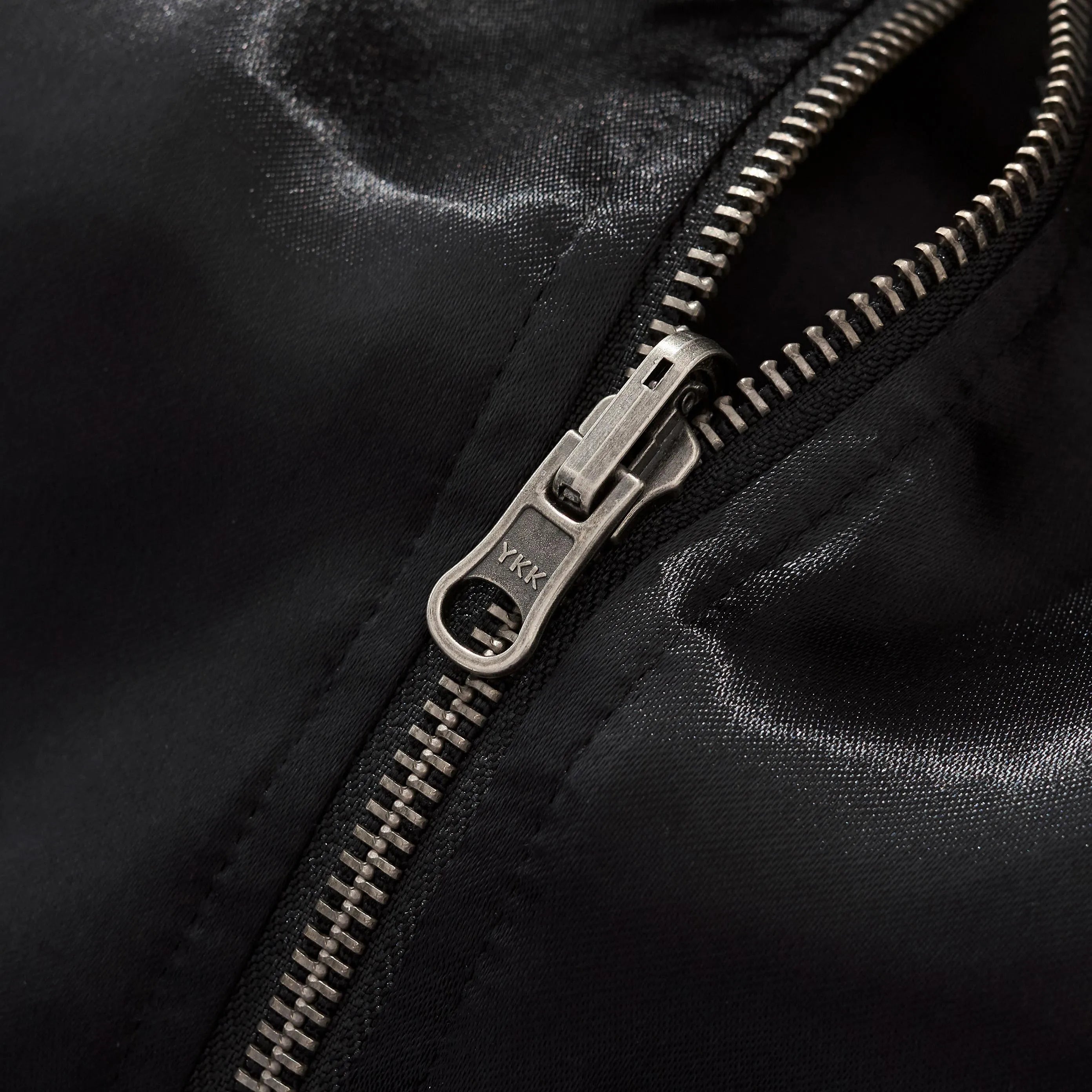 Close-up of the durable YKK metal zipper hardware.