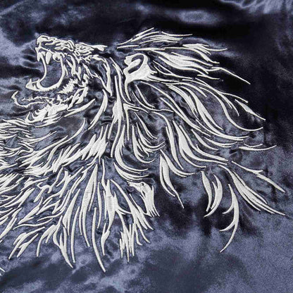 Close-up of the white lion’s flowing mane embroidery on navy satin.