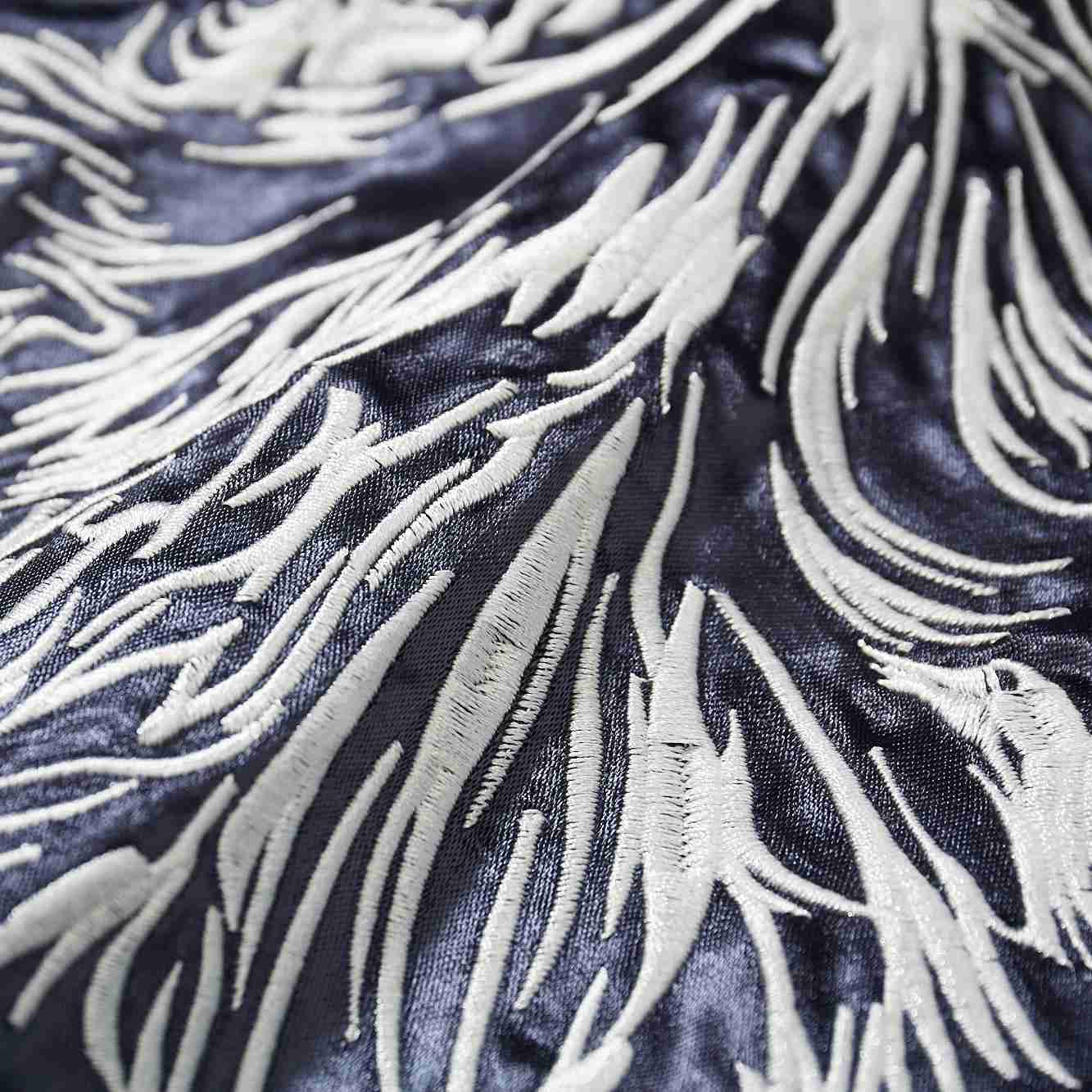 Macro view of raised satin stitches forming layered fur textures.