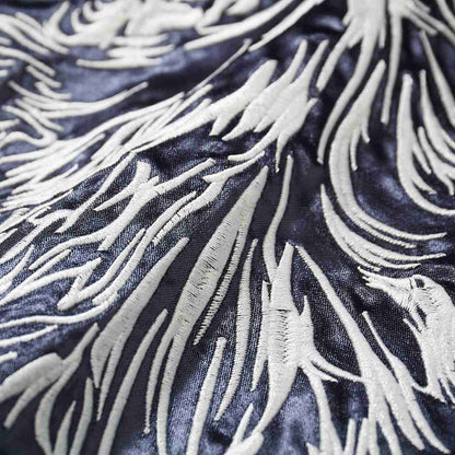 Macro view of raised satin stitches forming layered fur textures.