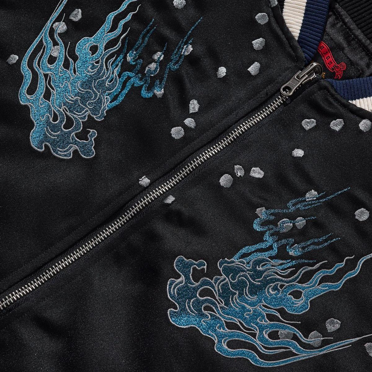 Close-up of the twin blue flame embroidery at the chest