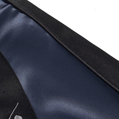 Close-up of navy satin sleeve with black piping